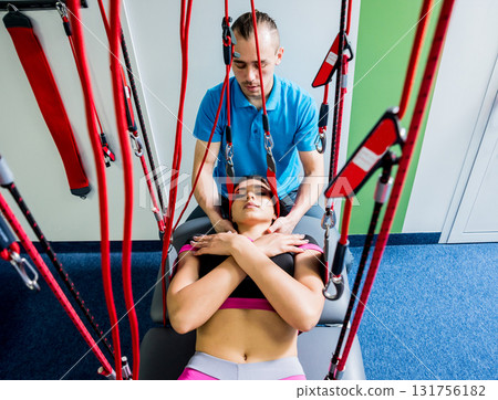 Physiotherapy. Suspension training therapy. Young woman doing fitness traction Physiotherapy. Suspension training therapy. Young woman doing fitness traction 131756182