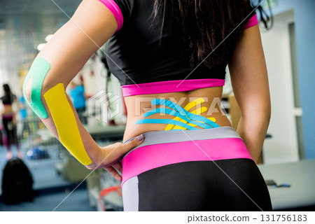 Kinesiotaping. Physical therapist applying tape to young beautiful womans spine 131756183