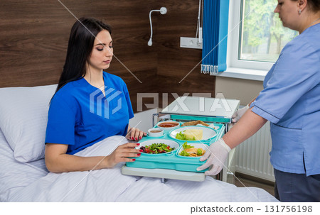 Nurse in medical coat is holding a tray with breakfast  131756198