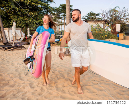 Two young surfers going into the sea with surf boards 131756222