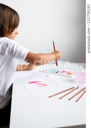 Young caucasian child painting with watercolors at home art session Young caucasian child painting with watercolors at home art session 131756281