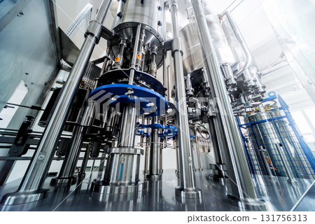 Automatic filling machine pours water into plastic PET bottles. 131756313