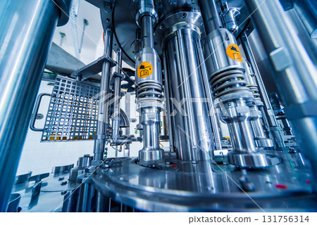 Automatic filling machine pours water into plastic PET bottles. Automatic filling machine pours water into plastic PET bottles. 131756314