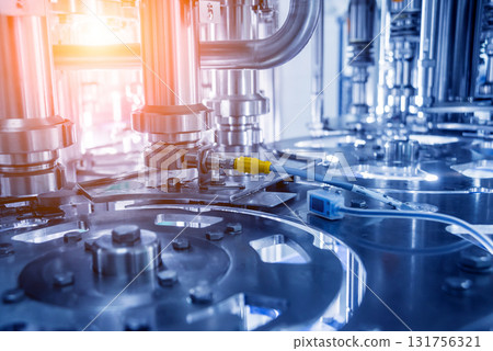 Automatic filling machine pours water into plastic PET bottles. 131756321