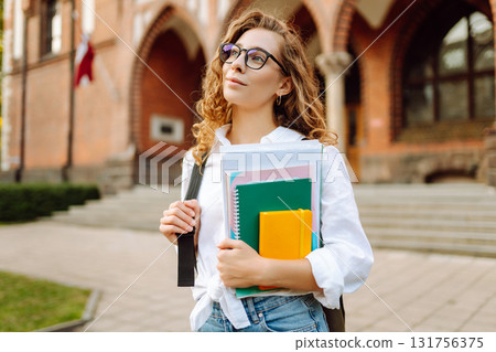 Student woman outdoors with bag and books near University. Education, friendship and people concept 131756375