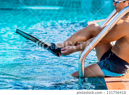 Young athletic man wearing flippers by the pool 131756418