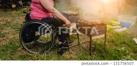 Disabled woman fries meat at the stake in a campsite with friends. Disabled woman fries meat at the stake in a campsite with friends. 131756507