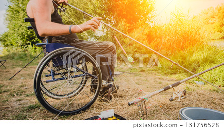 Handicapped man fishing at a lake. Wheelchair camping. 131756528