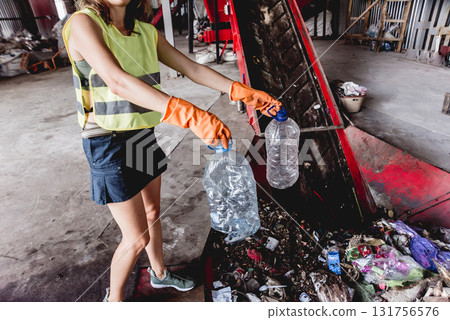 Woman-volunteer sorting trash at modern recycling plant. Woman-volunteer sorting trash at modern recycling plant. 131756576