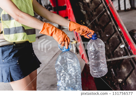 Woman-volunteer sorting trash at modern recycling plant. Woman-volunteer sorting trash at modern recycling plant. 131756577