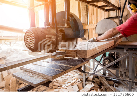 Modern sawmill. A carpenter works on woodworking the machine tool. Modern sawmill. A carpenter works on woodworking the machine tool. 131756600