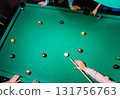Young man trying to hit the ball in billiard. 131756763