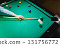 Young man trying to hit the ball in billiard. 131756772
