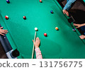 Young man trying to hit the ball in billiard. 131756775