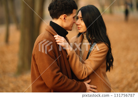 Young couple in love walking in the park on a autumn day. Enjoying time together. Young couple in love walking in the park on a autumn day. Enjoying time together. 131756787