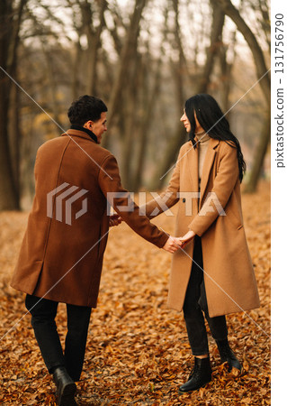 Young couple in love walking in the park on a autumn day. Enjoying time together. Young couple in love walking in the park on a autumn day. Enjoying time together. 131756790