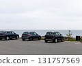 Parked cars on the seashore. Rocky seashore and houses in cloudy weather. 131757569