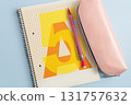 Closed school notebook with pencils on blue background 131757632