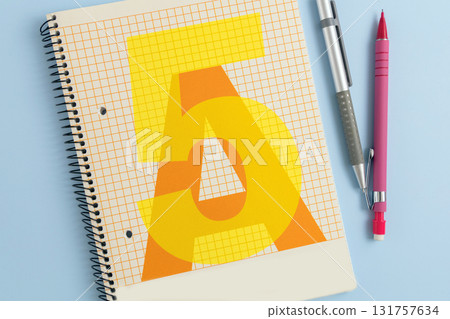 Closed school notebook with pencils on blue background 131757634