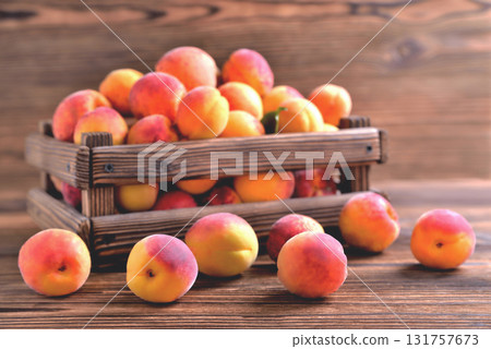 natural apricots in a wooden box on a natural wooden background, backlight soft focus natural apricots in a wooden box on a natural wooden background, backlight soft focus 131757673