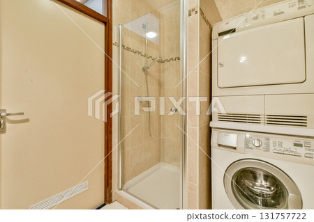 A compact and contemporary bathroom featuring a glass shower enclosure and stacked laundry units, showcasing a clean and efficient layout. A compact and contemporary bathroom featuring a glass shower enclosure and stacked laundry units, showcasing a clean and efficient layout. 131757722