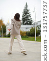 A senior woman twirls in place, smiling brightly as her coat flows. It reflects emotional well-being, freedom from judgment, and the stylish face of active aging. 131757737