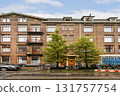 An aesthetically pleasing modern apartment building showcasing balconies and lush trees situated in an urban environment, complemented by parked bicycles. 131757754