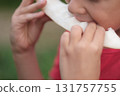 A child savors a fresh melon slice, his attention captured in the act. This image invites viewers to appreciate the freshness of summer produce. 131757755