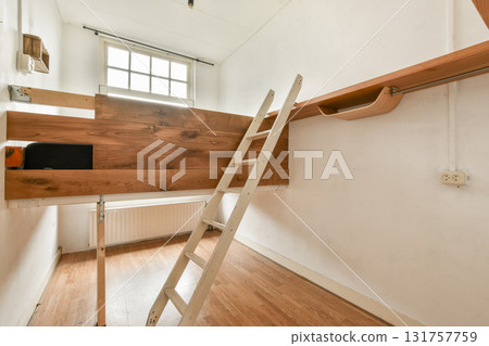An elegant, modern interior showcasing wooden elements, a ladder, and clean lines. Bright natural light enriches the minimalist design. An elegant, modern interior showcasing wooden elements, a ladder, and clean lines. Bright natural light enriches the minimalist design. 131757759