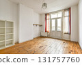 An empty, sunlit room featuring wooden floors, large windows with colorful curtains, and minimal furnishings. Ideal for a fresh start or design inspiration. 131757760