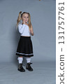 little girl stands in a fun and expressive pose, her fists playfully raised. The photo captures the energy and spontaneity of childhood, paired with her fashionable outfit. 131757761