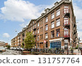An inviting view of a historic building on a lively city street adorned with bicycles and greenery, showcasing urban charm and character. 131757764