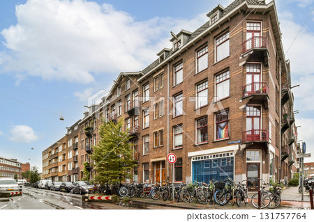 An inviting view of a historic building on a lively city street adorned with bicycles and greenery, showcasing urban charm and character. 131757764