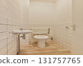 A clean and minimalistic bathroom showcasing white tiled walls, a simple toilet, and modern plumbing fixtures in a compact space. 131757765