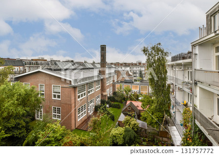 A view of a residential complex showcasing greenery, solar panels, and modern architecture, creating a harmonious blend of nature and sustainability. 131757772