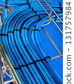 Colorful blue hoses arranged neatly on metal racks in a workshop setting 131757984