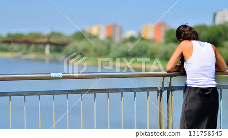 Depressed woman standing on a bridge. Negative attitude. Suicide prevention concept Depressed woman standing on a bridge. Negative attitude. Suicide prevention concept 131758545