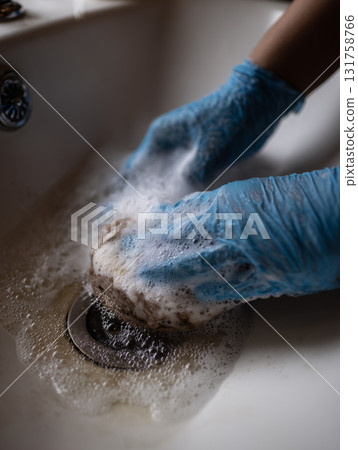 Cleaning a sink with gloves and soap to remove dirt and grime effectively Cleaning a sink with gloves and soap to remove dirt and grime effectively 131758766