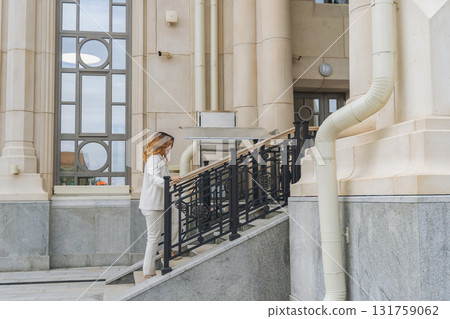 Woman, Stairs, Building - Woman descending stairs outside of a building with a large window. Woman, Stairs, Building - Woman descending stairs outside of a building with a large window. 131759062