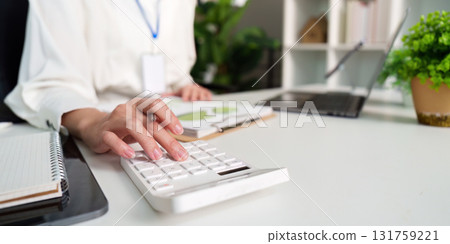 Business professional using calculator for financial analysis in office Business professional using calculator for financial analysis in office 131759221
