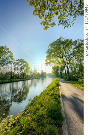 A Serene Riverside Pathway at Dawn, Surrounded by Lush Greenery, Ideal for Relaxation 131759949