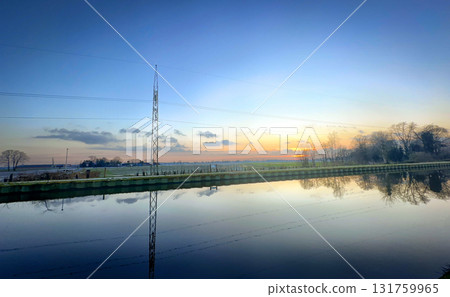 A Beautiful and Tranquil Sunset Reflection Over Calm and Serene Water as the Day Turns into Night 131759965