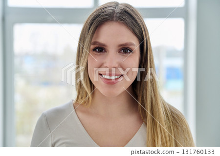 Headshot portrait of young happy woman looking at camera 131760133