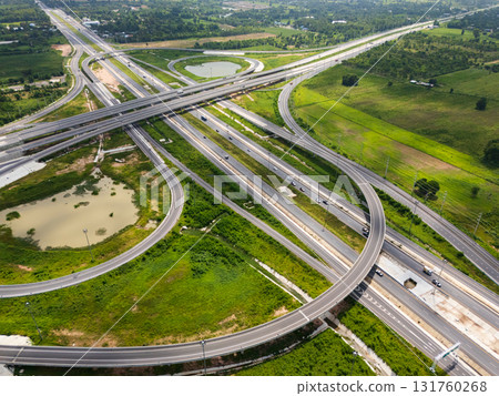 Drone shot a large highway interchange crossing over green farmlands in Thailand 131760268