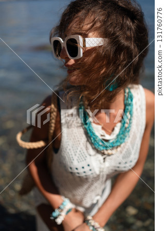 Woman, curly hair, sunglasses in white crochet top with bohemian style at a sunny outdoor location Woman, curly hair, sunglasses in white crochet top with bohemian style at a sunny outdoor location 131760776