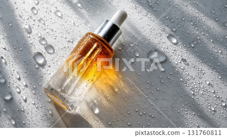 Bottled golden serum on wet surface 131760811