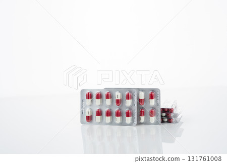 Red and white antibiotic capsule pill in blister pack. Prescription drug clindamycin 300 mg for bacterial infection treatment healthcare and pharmaceutical use. Healthcare and medicine industry. 131761008