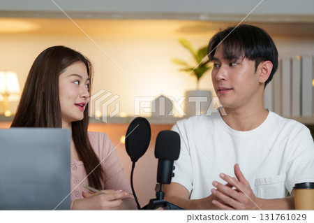 Podcasting duo. Engaging conversation between two young adults in a cozy studio. 131761029