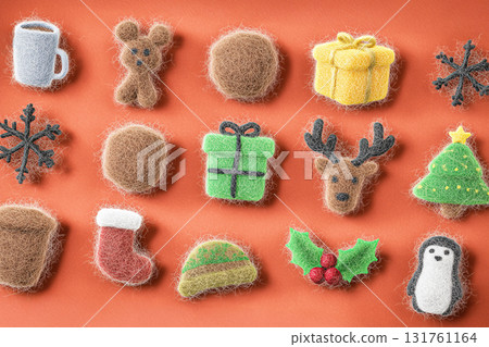 Colorful handmade felt decorations are displayed on an orange background. The collection includes snowflakes, gifts, and holiday animals, perfect for seasonal cheer. AI 131761164
