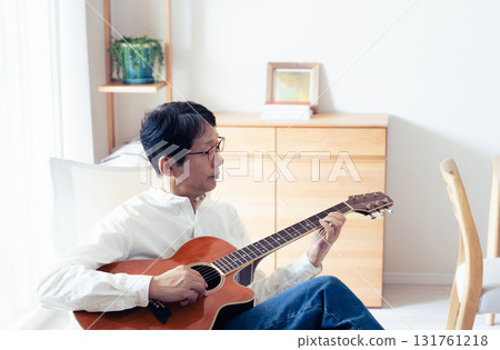 中年男子在客廳彈吉他 131761218
